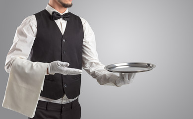 Waiter serving with white gloves and steel tray in an empty space
