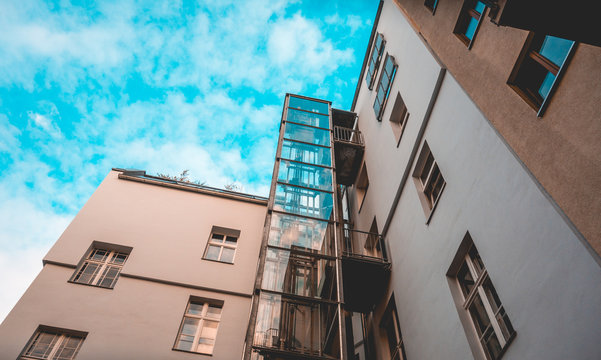 glass elevator at apartment house with fluffy background sky