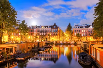Poster Beautiful cityscape of the famous canals of Amsterdam, the Netherlands, at night with a mirror reflection and a full moon © dennisvdwater