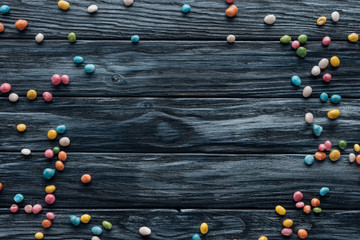 elevated view of arranged colorful delicious candies on wooden background