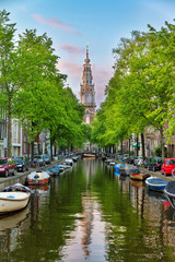 Beautiful Groenburgwal canal in Amsterdam with the Soutern church (Zuiderkerk) at sunset in summer