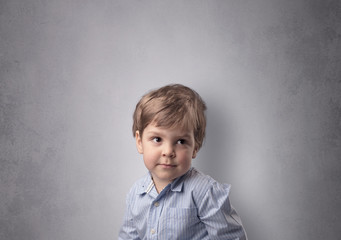 Fototapeta premium Adorable little boy portrait with empty grey wall background