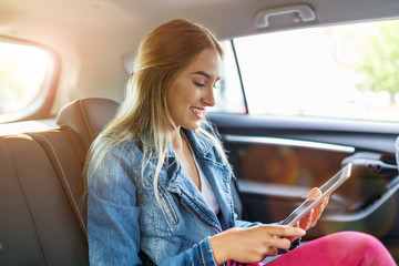 Young woman using a tablet in a car
