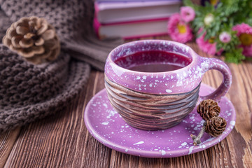 Red fruit tea, books and flowers asters on a wooden background