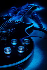 Electric guitar,headphones and microphone.Music concept.Selective focus.In the dark