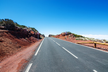 Mountain road over the clouds. Traffic warning signs 