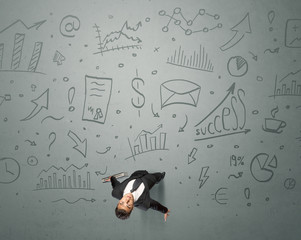 Young contemplating businessman stands in front of business graphics