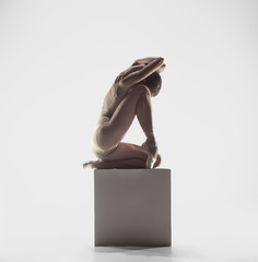 Young graceful female ballet dancer or classic ballerina dancing on white studio. Caucasian model...
