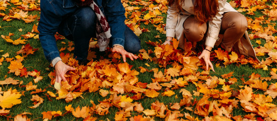 love, relationship, family and people concept - close up of couple with maple leaf in autumn park.two people, a couple, a man and a woman, throw yellow wedge leaves.