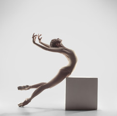 Young graceful female ballet dancer or classic ballerina dancing on white studio. Caucasian model on pointe shoes - obrazy, fototapety, plakaty