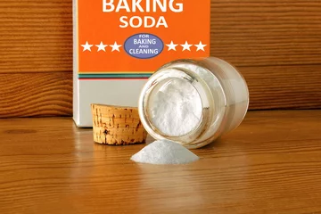  baking soda or baking powder in bottle isolated in wooden background for cooking recipe or cleaning © gv image