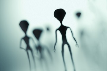 Spooky silhouettes of aliens and bright light in background. 3D rendered illustration. - obrazy, fototapety, plakaty