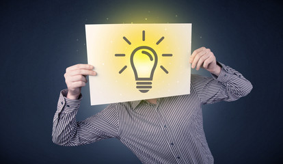 Young businessman hiding behind a lightbulb drawn on paper