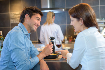 Couple sat at bar eating