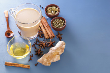 Tea masala on milk with spices ingredients - cinnamon, cardamom, ginger, cloves, tubby, sweet pepper, honey. Copy space