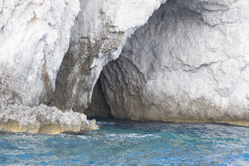 Fototapeta na wymiar One of the coastal caves of the Ortigia island in Sicily. The water here is very clear and many boat trips for tourist are organized every day
