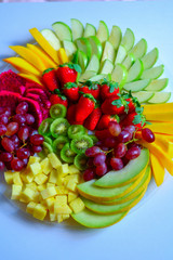 Fruit platter with fresh grapes, apple, pineapple, kiwi, mango, red ripe strawberry and pitaya. Colorful Fruit tray best health good food for party and holidays table.