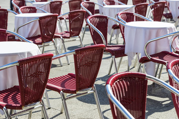 Rows of tables and chairs on the street in a restaurant 