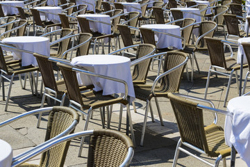 Rows of tables and chairs on the street in a restaurant 