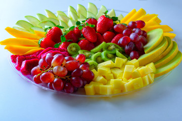 Fruit platter with fresh grapes, apple, pineapple, kiwi, mango, red ripe strawberry and pitaya....