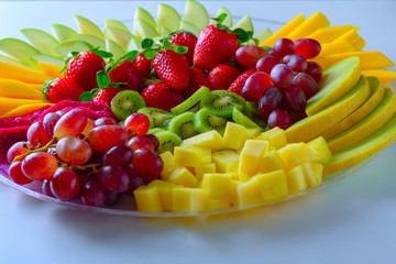 Fruit platter with fresh grapes, apple, pineapple, kiwi, mango, red ripe strawberry and pitaya. Colorful Fruit tray best health good food for party and holidays table.