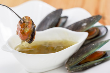 seafood mussels with spicy seafood sauce on wooden background