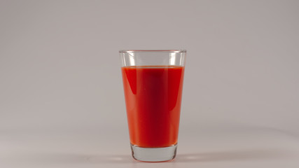 Full glass with an tomato juice on a white background