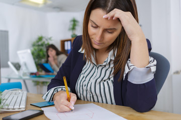 female office worker writing something on paper