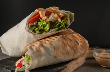 Shawarma with chicken and tomato. Put on a wooden background