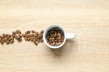 Coffee beans with cup on wooden table