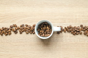 Coffee beans with cup on wooden table