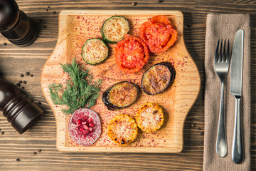 vegetables cooked on a grill on a wooden board with spices