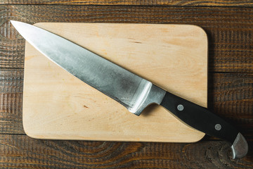board with a knife on a wooden background