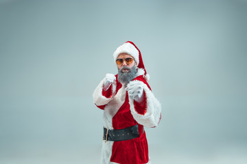 Funny aggressive boxing guy with christmas hat posing at studio. New Year Holiday. Christmas,...