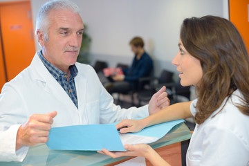 Obraz premium Doctor and receptionist looking at files