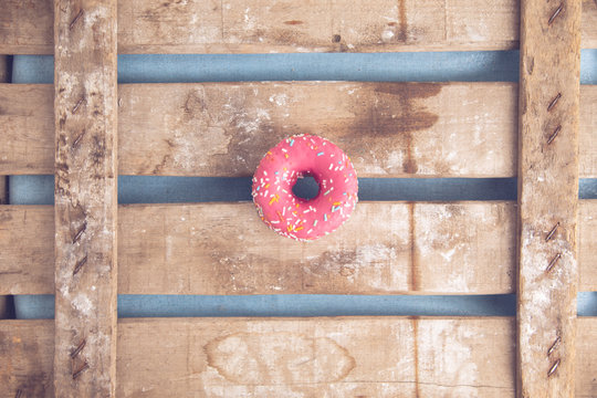 pink donut on wooden background