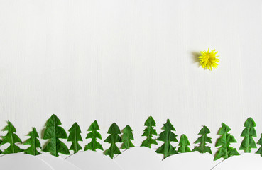 on a light background in the background a line of Christmas trees made from dandelion leaves and white snow drifts sun flower applique children's copy space