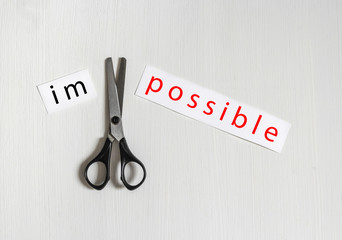 on a light background a hand holds a pair of scissors cuts a piece of paper an inscription is...