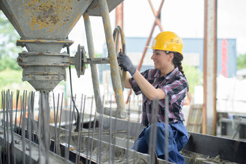 Woman turning wheel on cement hopper