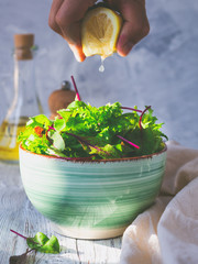 Sprinkling salad with lemon juice.
