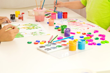 Children paint with gouache, paints , pencils. Mobile and entertainment Board games for children.Ceramic dishes in working process. Creating color patterns.