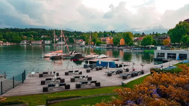 Reveal shot of Falkensteiner Schlosshotel and port in Velden Am Worthersee lake sunset dusk