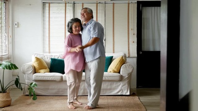 Senior man and woman dancing together at home. Senior people with relax time at home. 