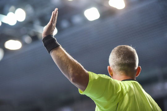 handball referee with raice hand
