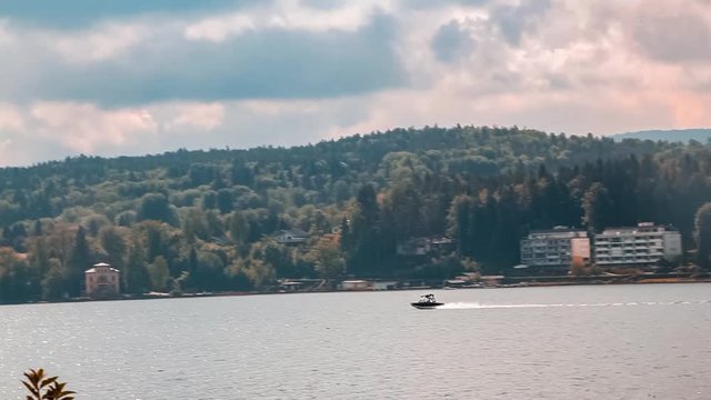 Tracking shot floating speed boat on Worthersee river lake mountain view Austria