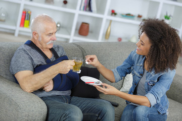 male caregiver helping disabled male pensioner