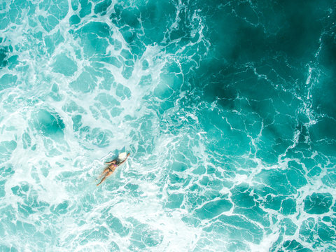 aerial shot leaky peak drone a-frame sumbawa surf ocean crystal white paddle girl