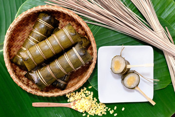 Glutinous rice steamed in bamboo bowl on banana leaf .