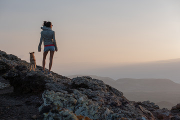 girl on the top of the volcano with her dog
