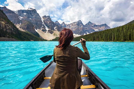 Female tourist rowing boat on Moraine Lake in Banff National Park, Canadian Rockies, Alberta, Canada.
